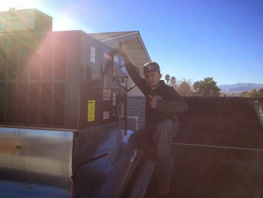 HVAC technician performing AC Tune-Up on a rooftop unit in West Warwick